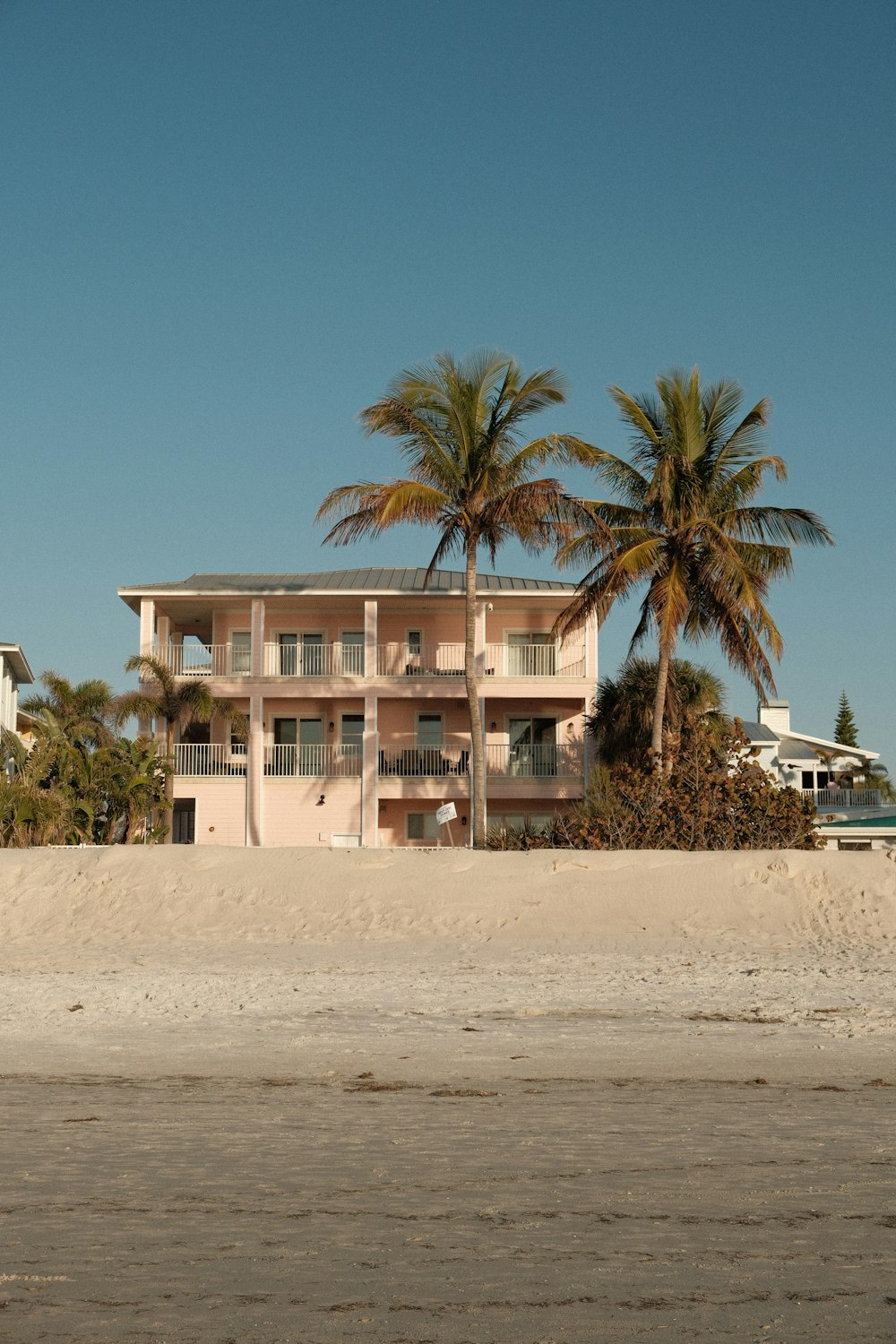 a pink building with palm trees in front of it