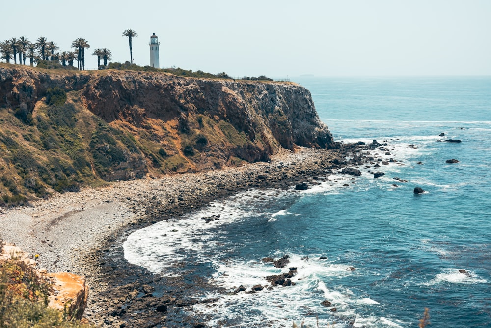 a lighthouse on a cliff overlooking the ocean