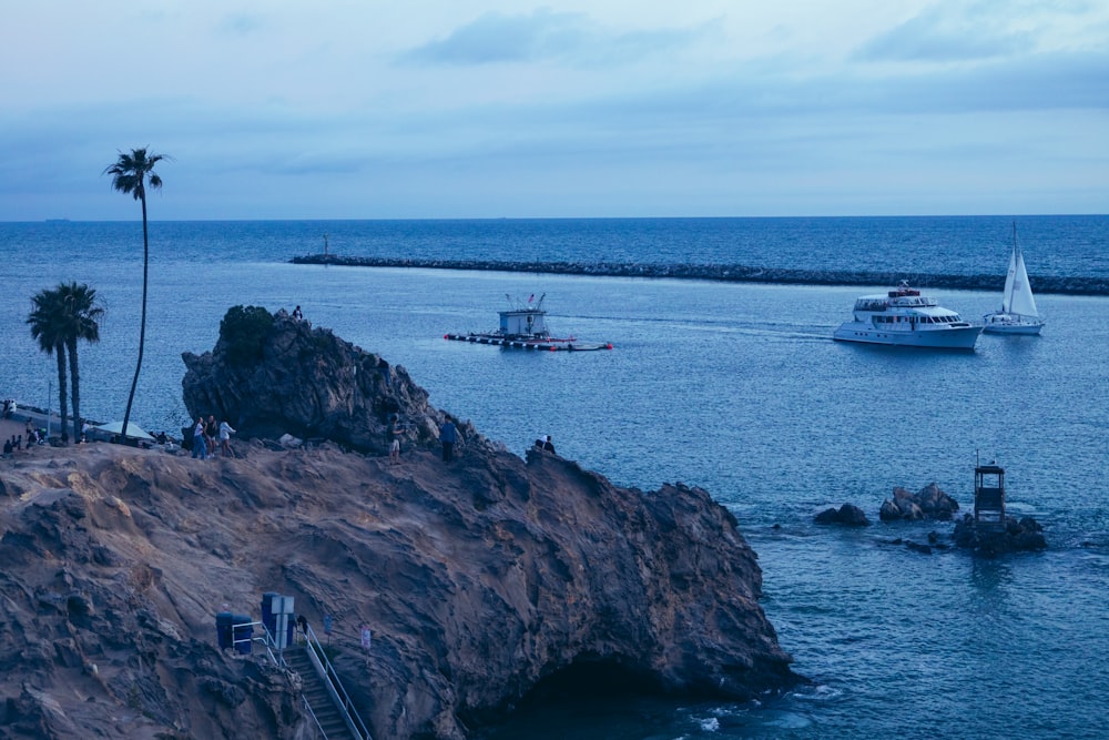 a boat is in the water near a rocky shore