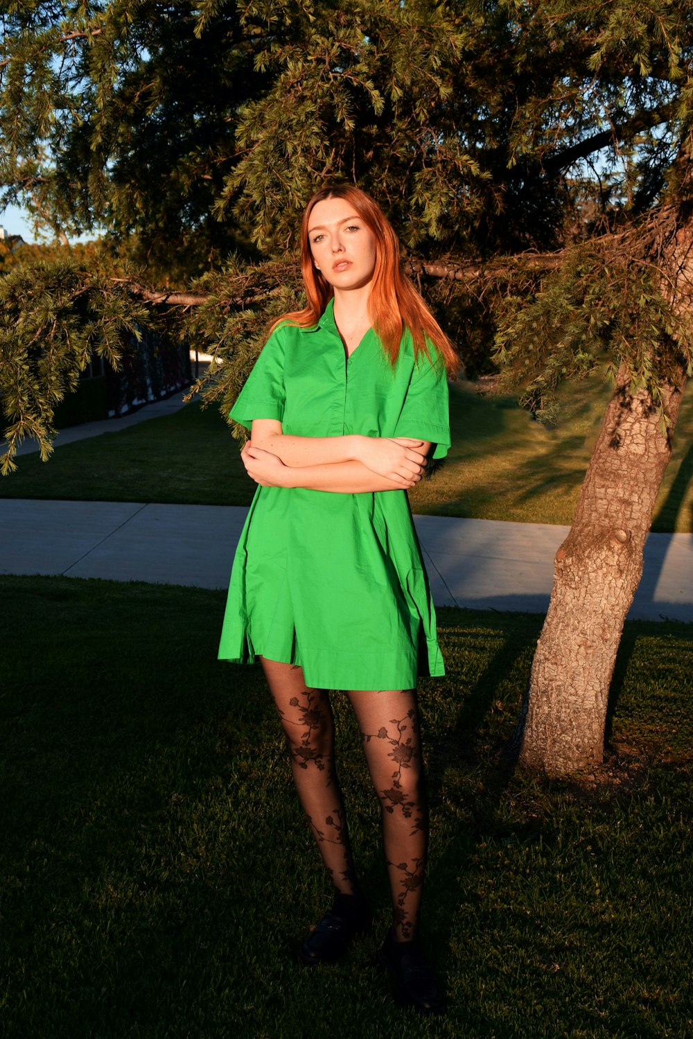 a woman in a green dress standing in the grass