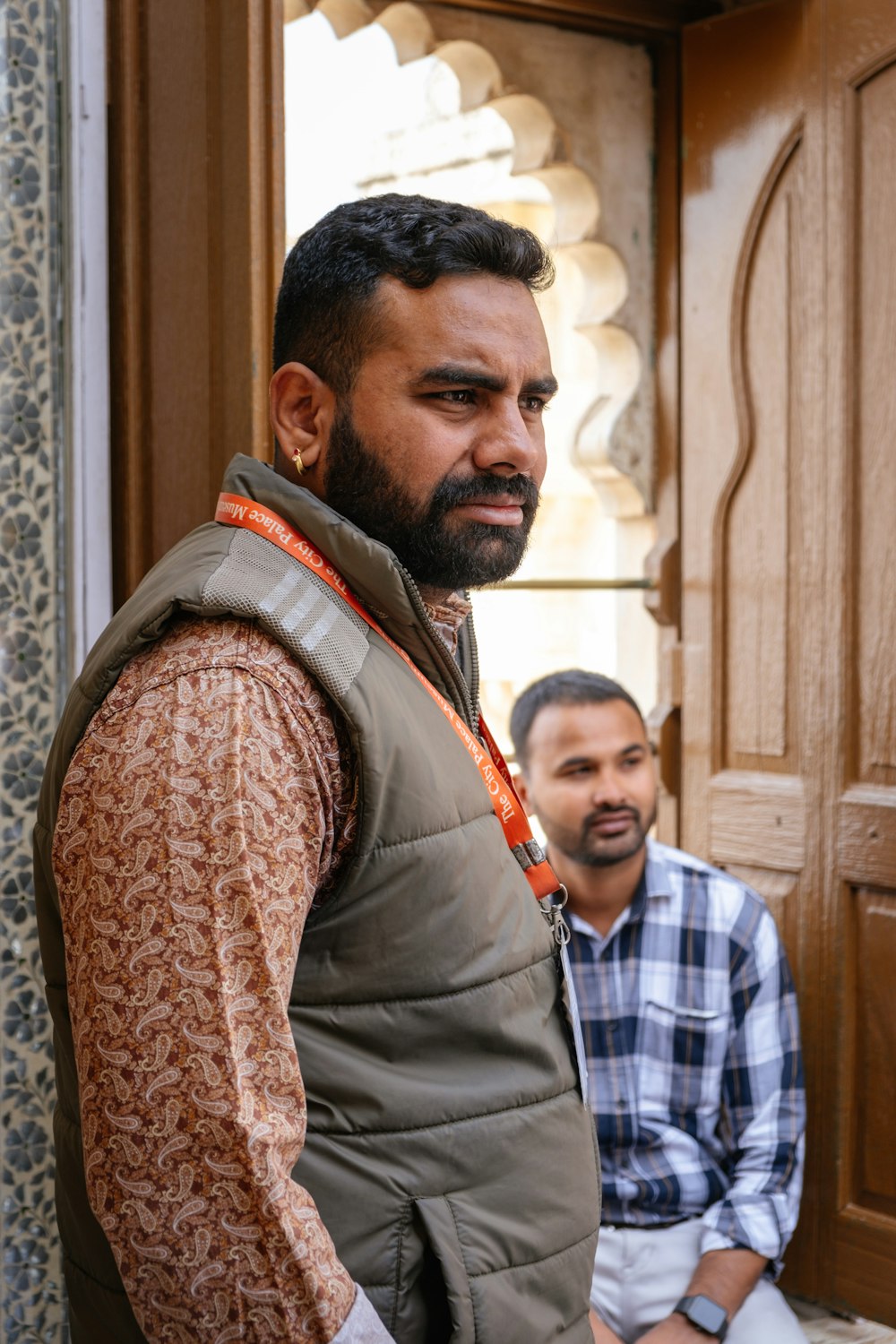 a man standing next to another man in front of a door