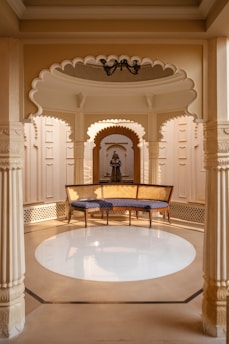 a room with a bench and a chandelier