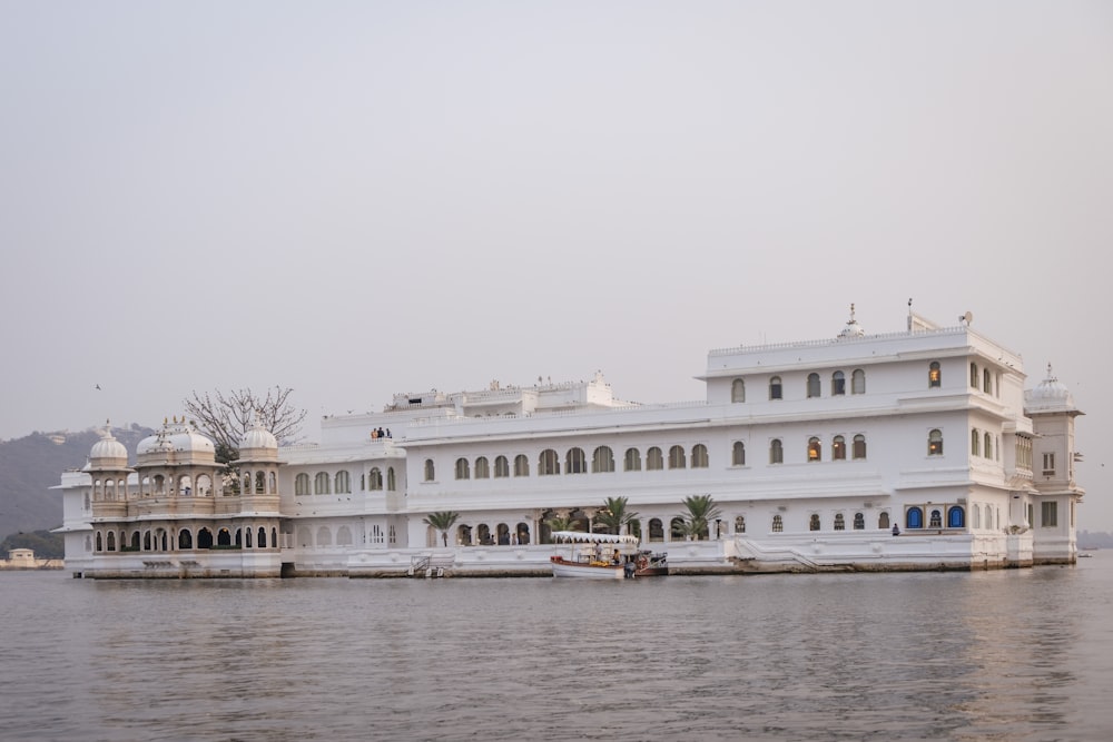 a large white building sitting on top of a body of water