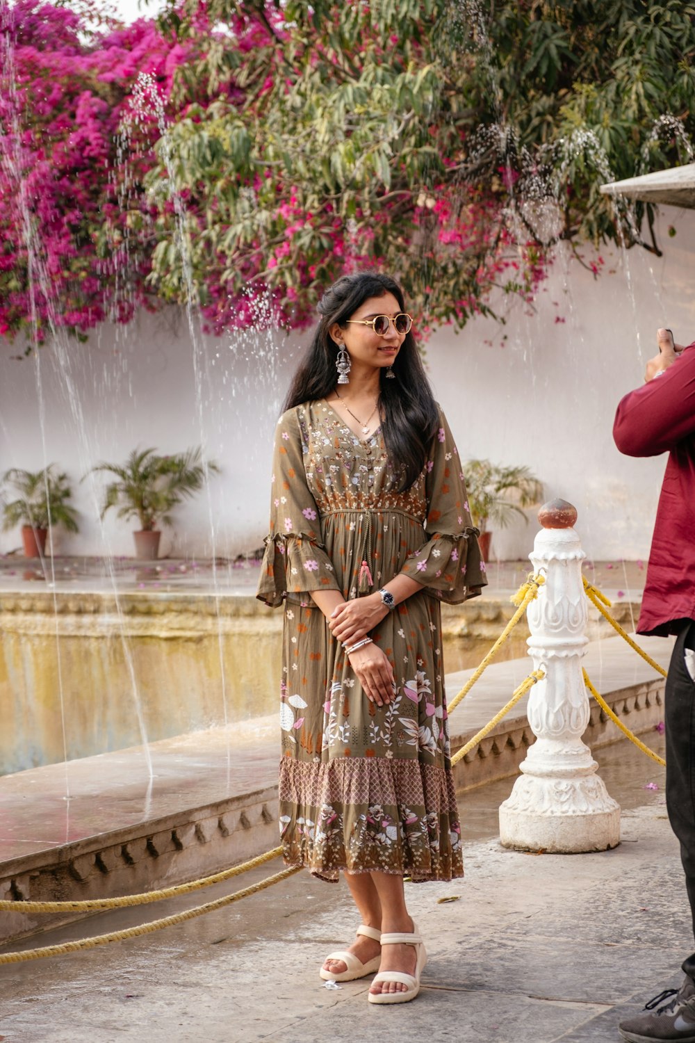 a man taking a picture of a woman in front of a fountain