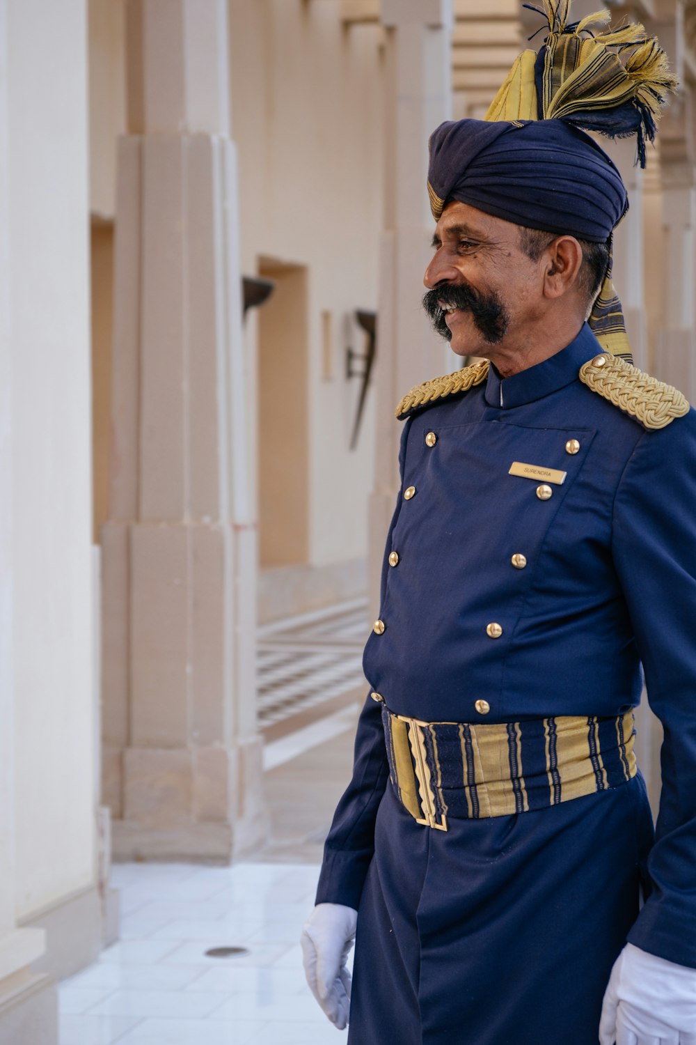 um homem de uniforme azul parado em um corredor