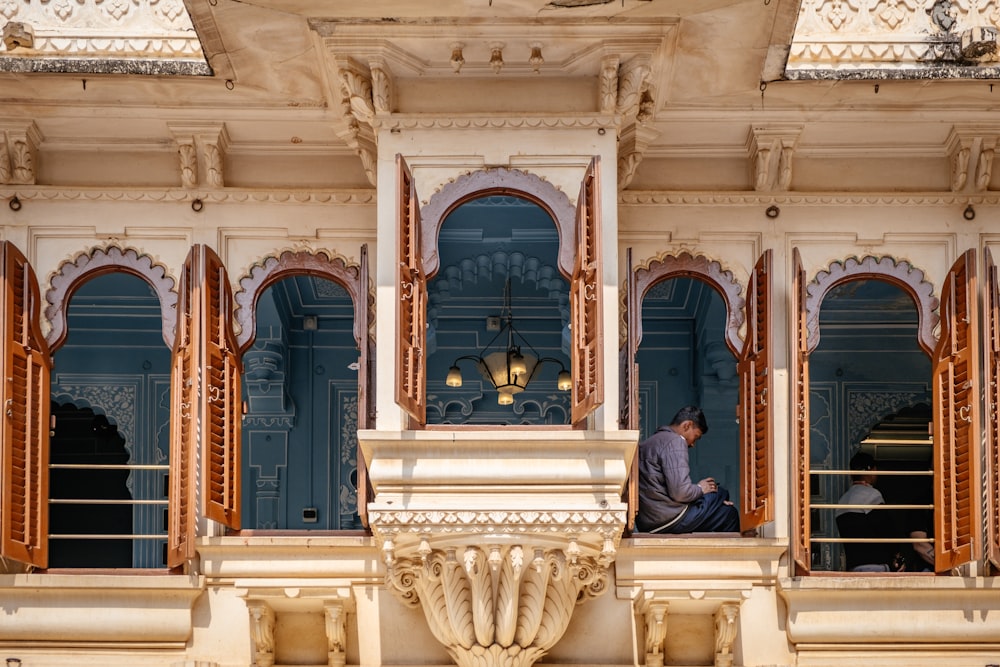 a man sitting on a balcony of a building