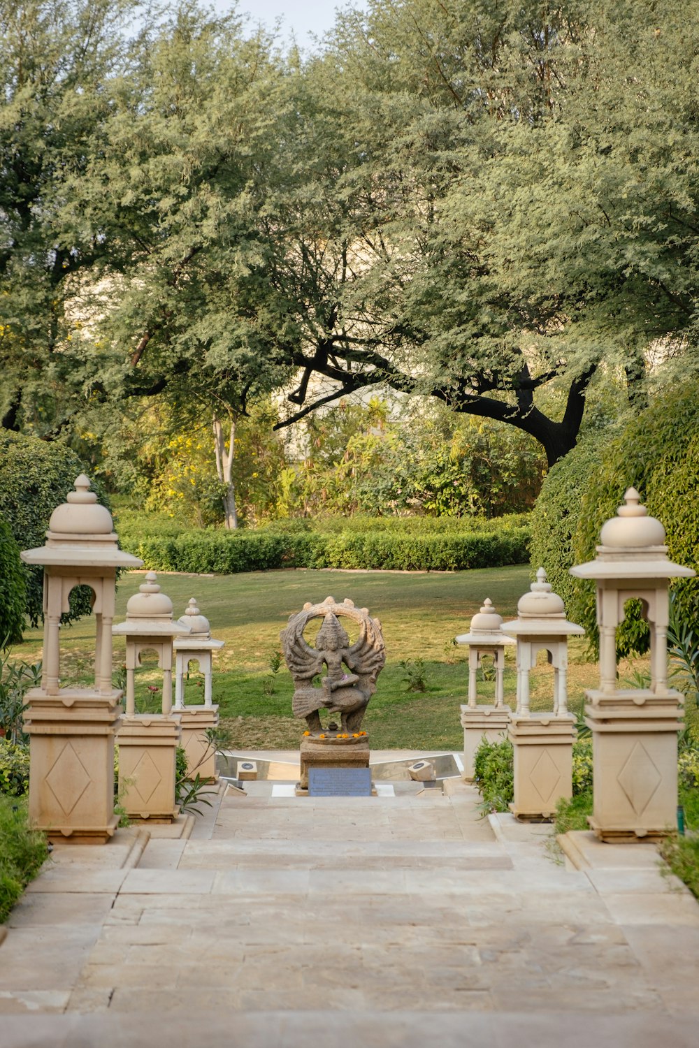 a garden with a fountain surrounded by trees