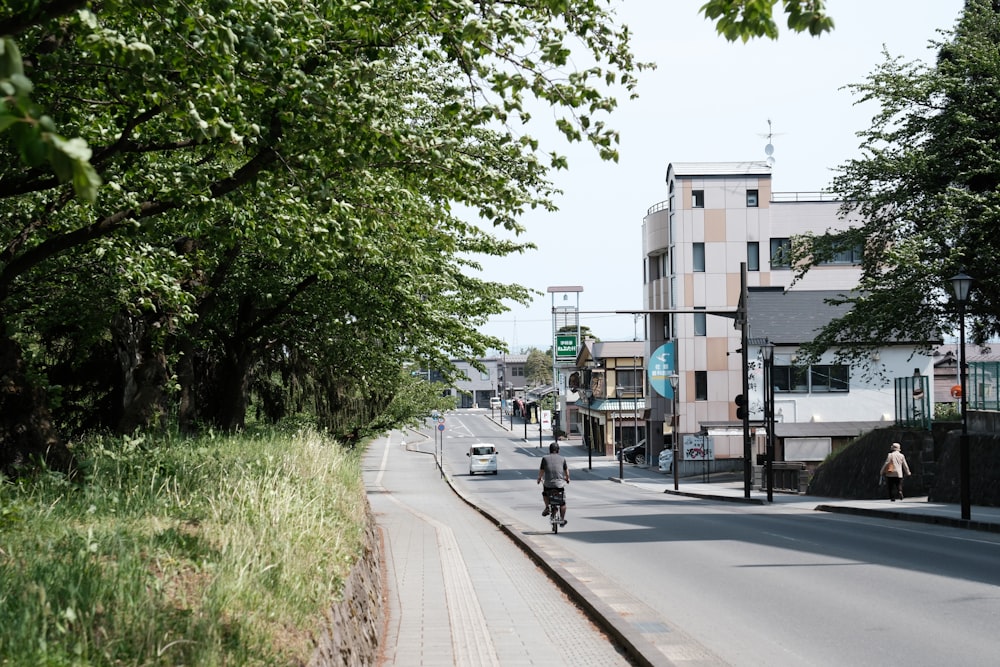 a man riding a bike down a street next to tall buildings