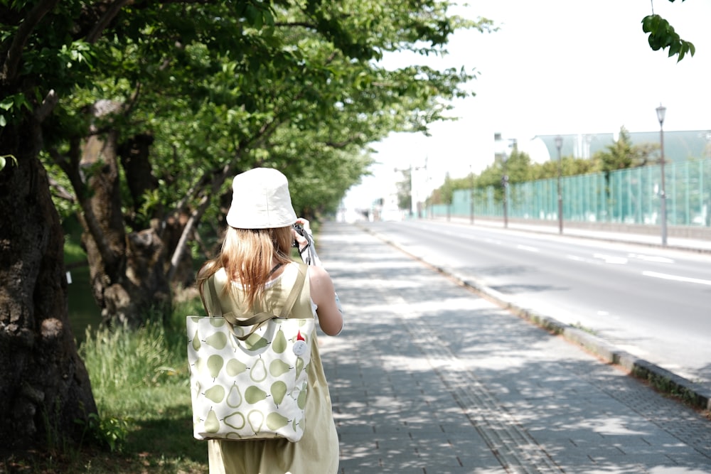 a woman walking down a street while holding a cell phone