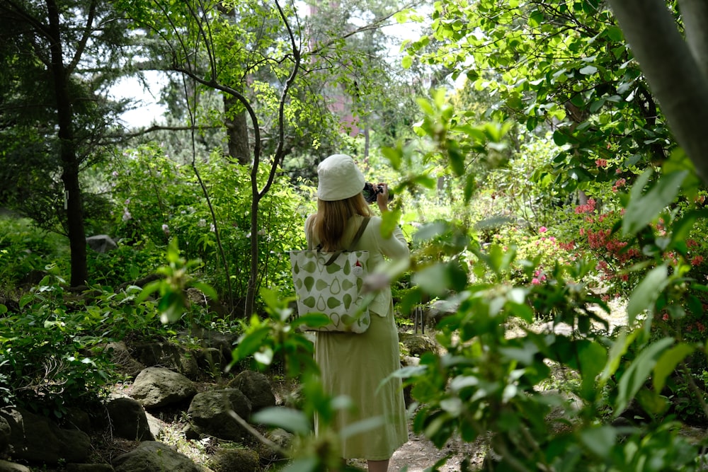 a woman in a white hat is taking a picture