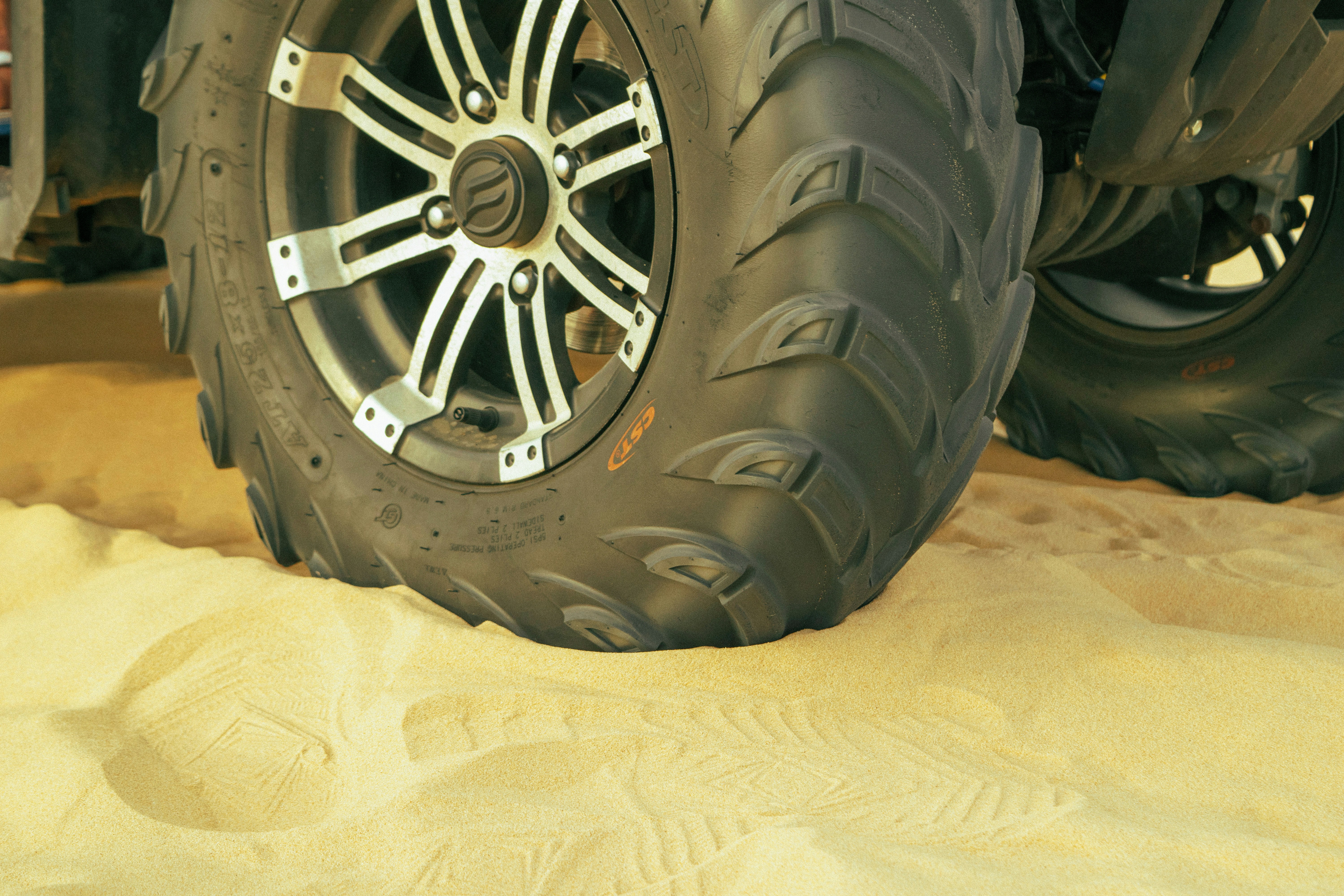 A close-up photograph of a golf cart tire sidewall clearly showing the size and ply rating markings in a service garage