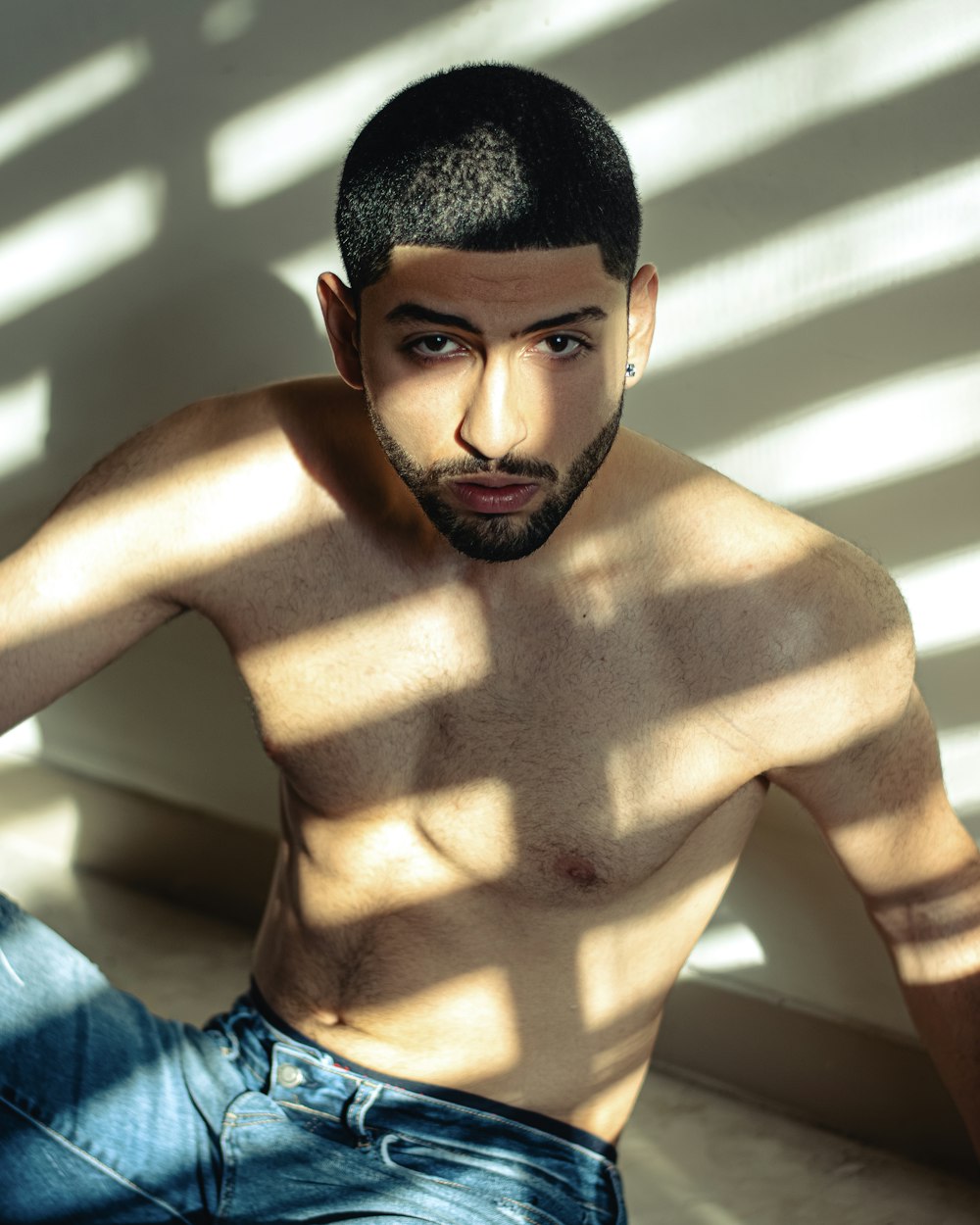 a shirtless man sitting on the floor in a room