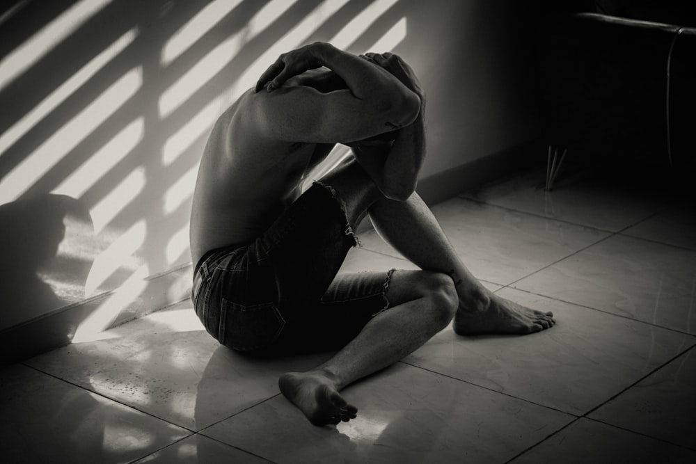 a man sitting on the floor in front of a window