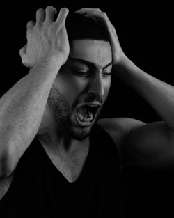 a man holding his head with his hands