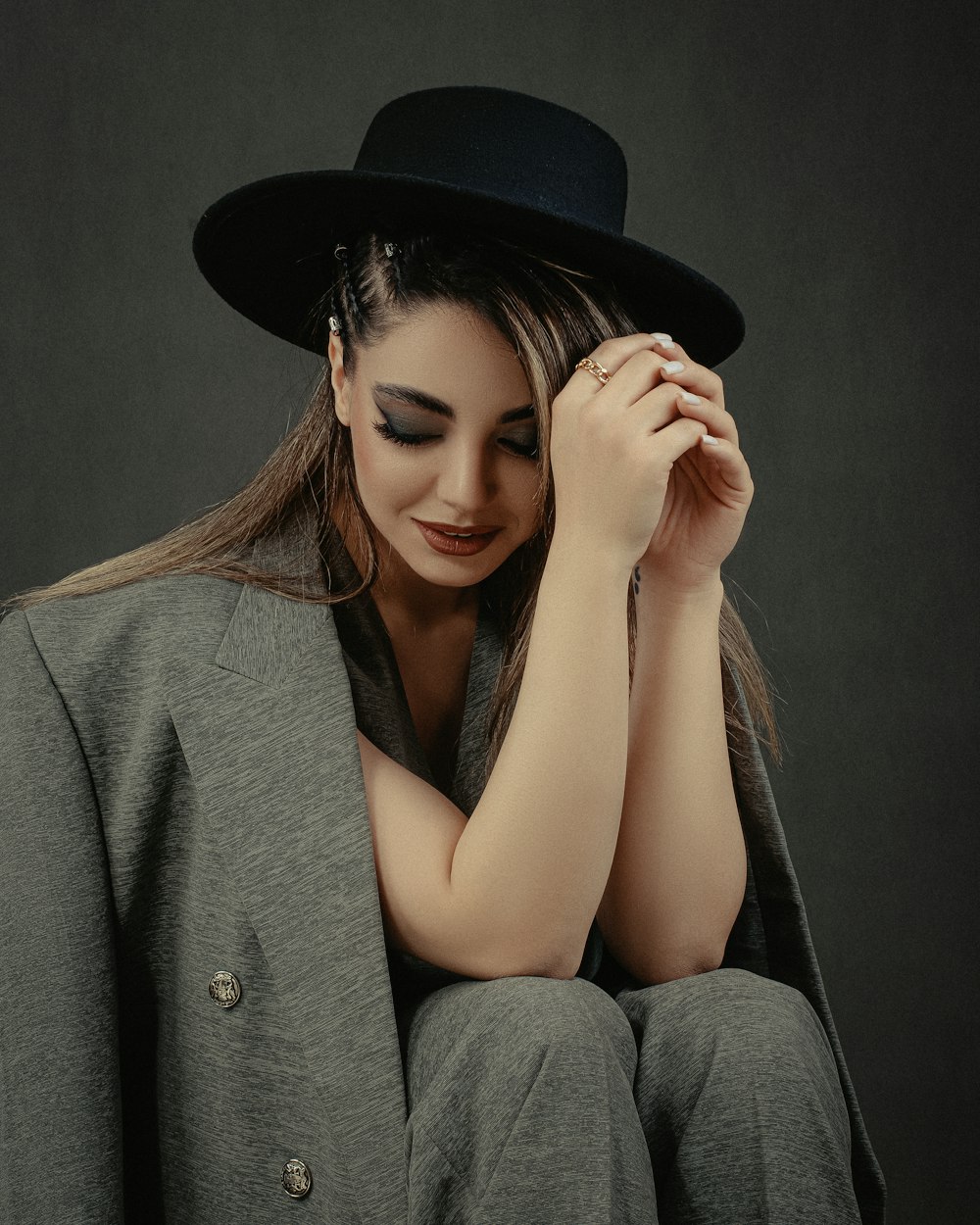 a woman wearing a black hat sitting on a chair