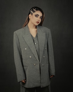 a woman in a gray jacket and black pants