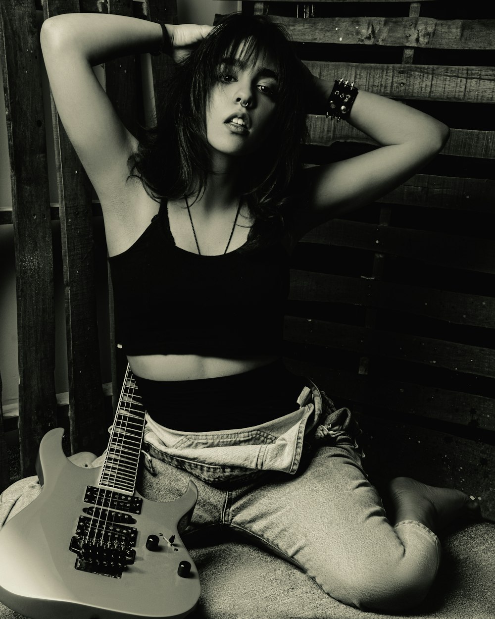 a woman sitting on the floor with a guitar