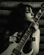 a woman holding a guitar up to her face