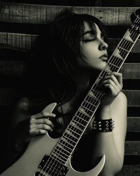 a woman holding a guitar up to her face