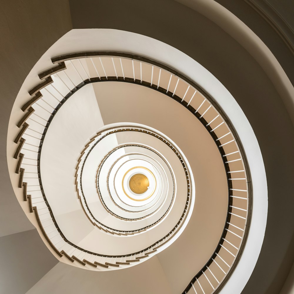 a spiral staircase in a building with a yellow light