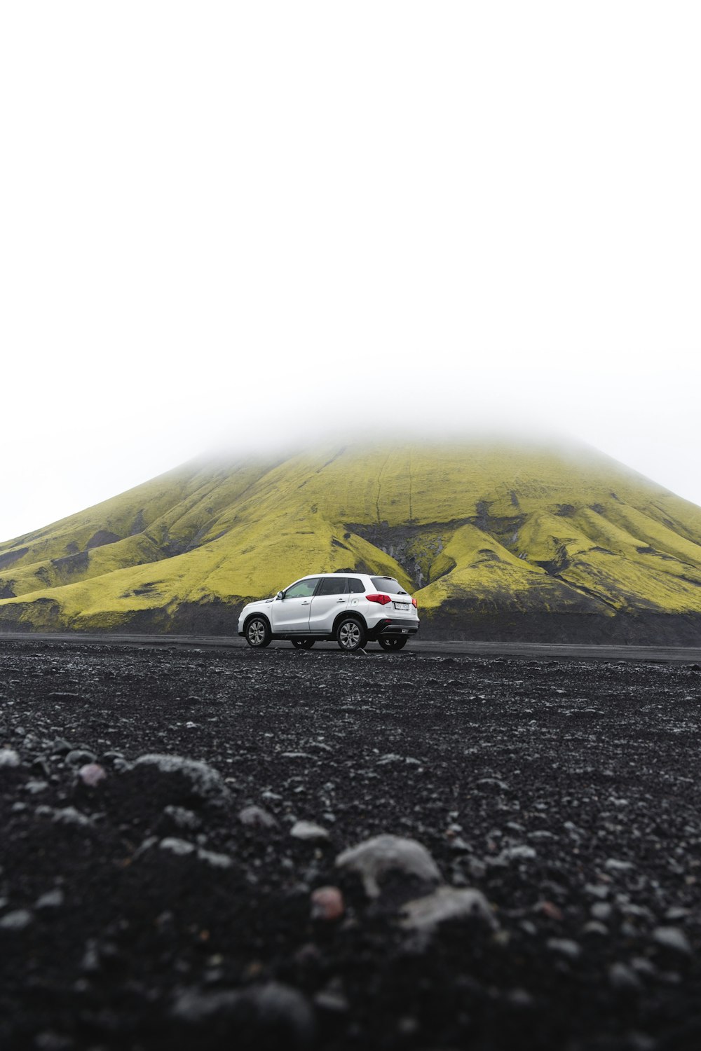 une voiture est garée devant une montagne