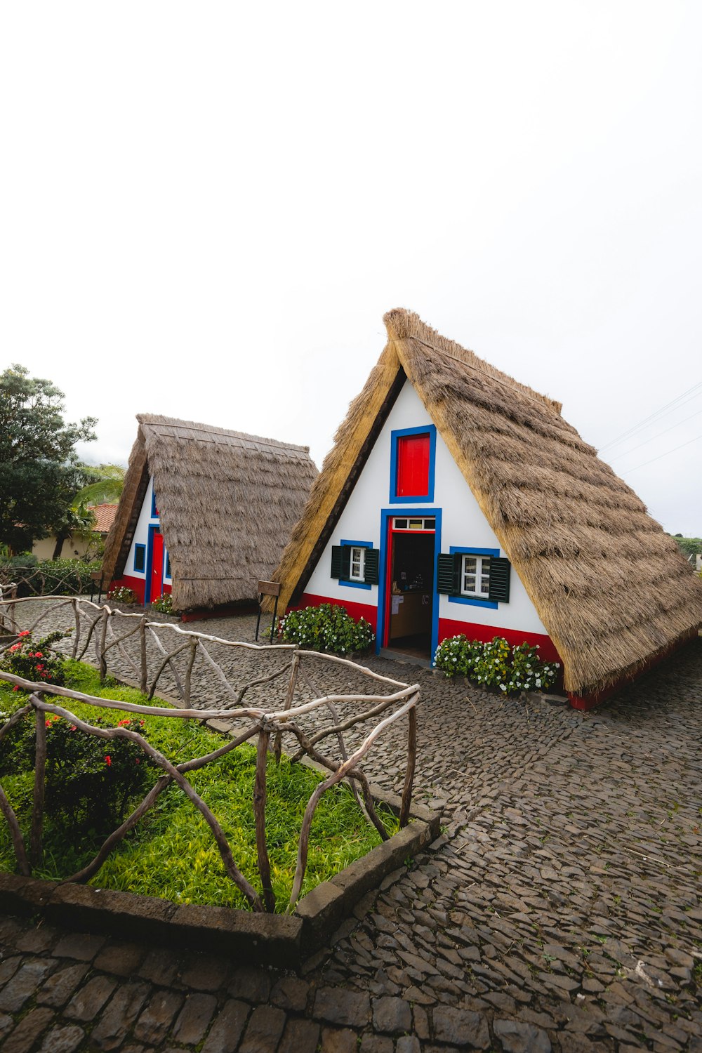 a row of thatched roof houses on a cobblestone road