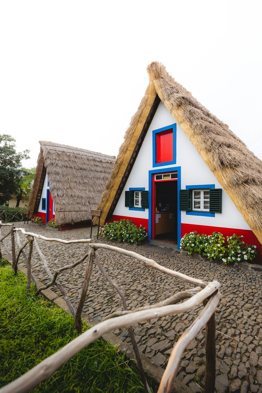 a white and red house with a thatched roof