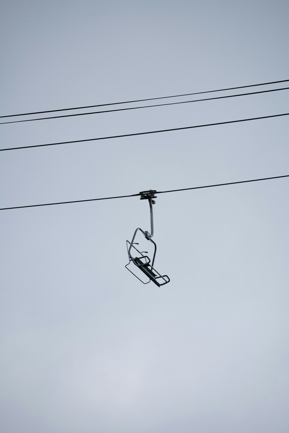 a ski lift suspended from a wire in the sky