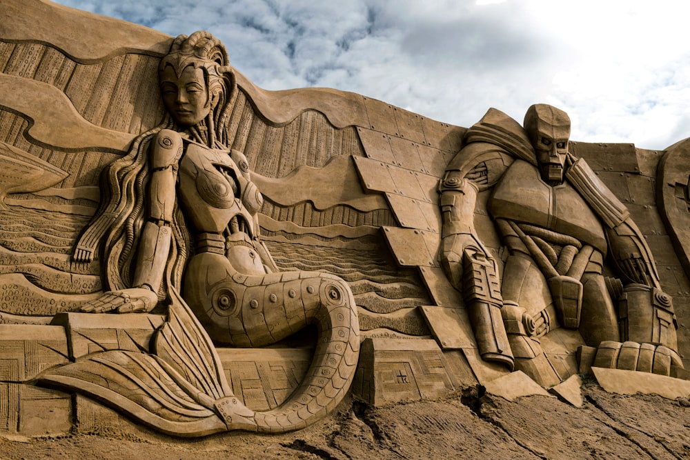a sand sculpture of a mermaid and a man
