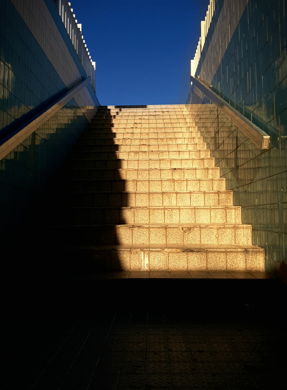 a stairway with a shadow of a person walking up it