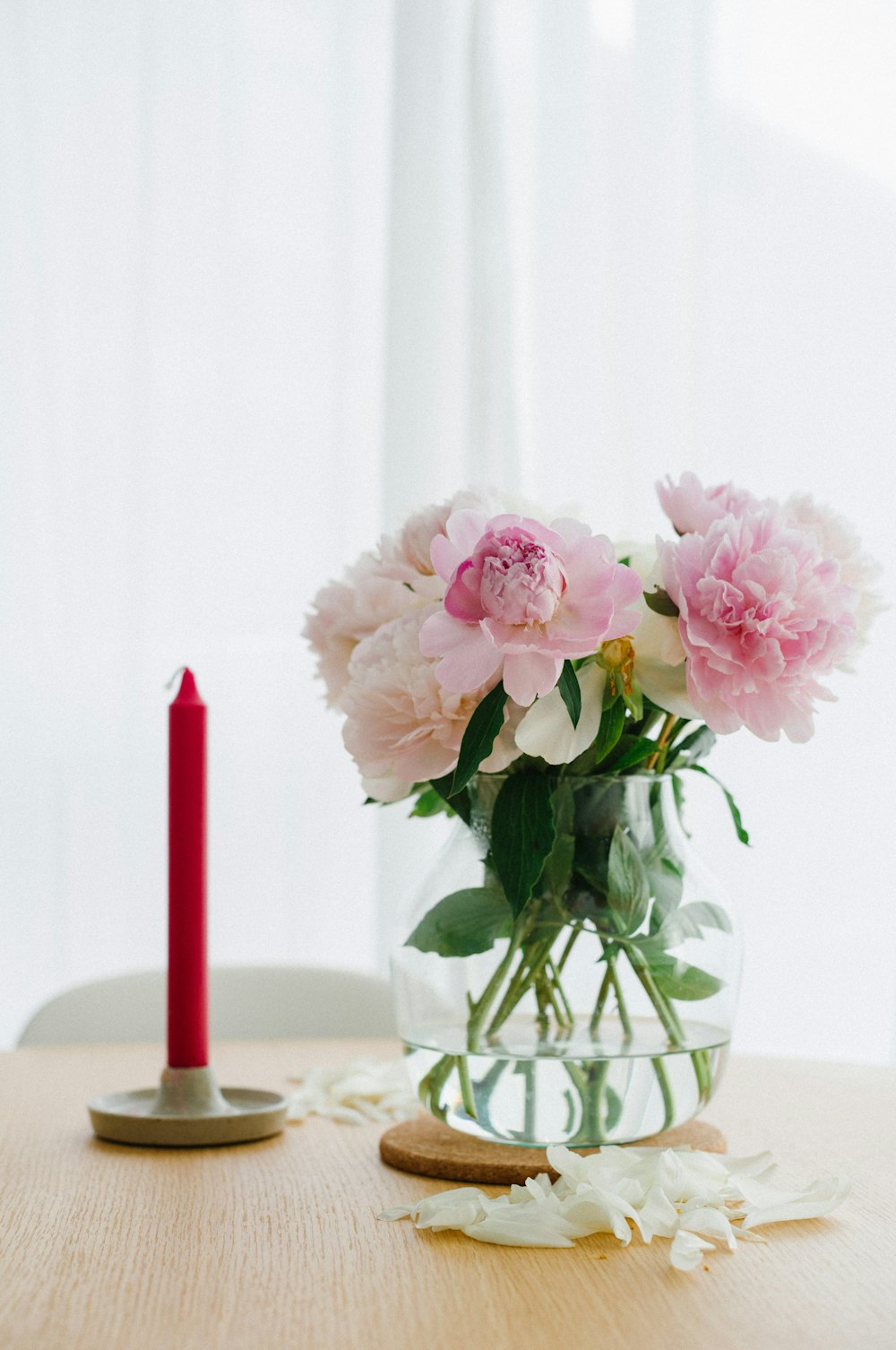 a vase of flowers on a table next to a candle