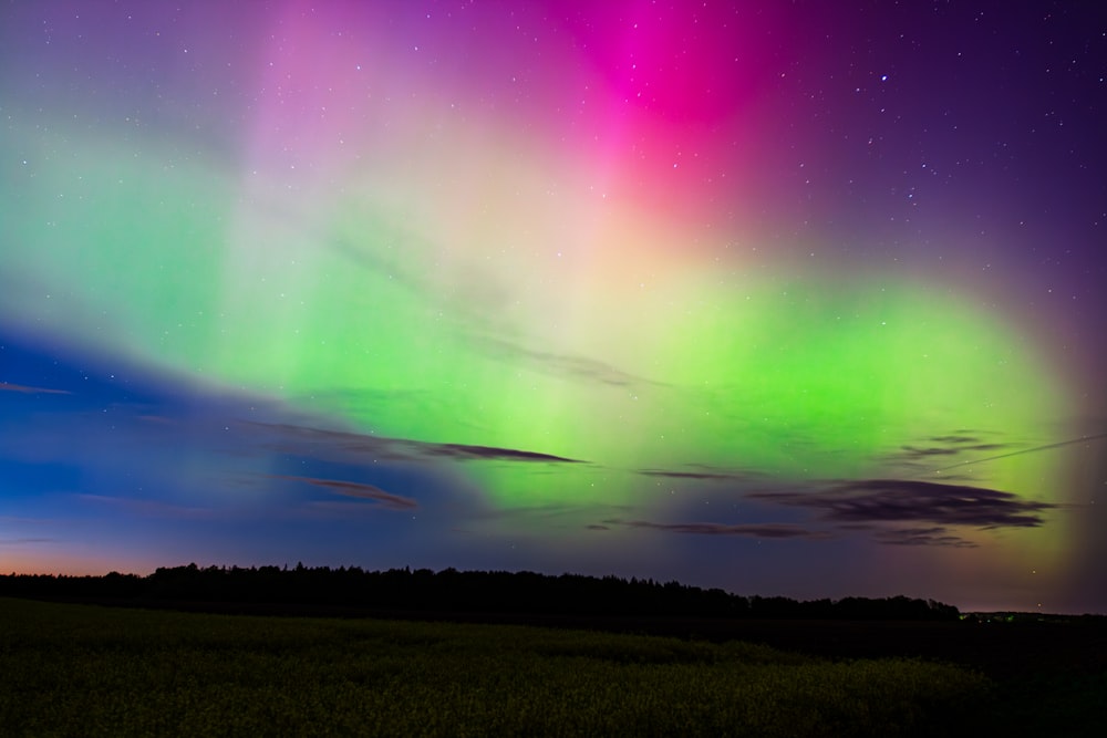 a bright green and purple aurora bore in the night sky