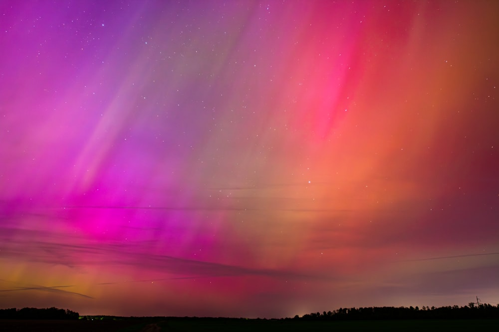 a bright purple and pink aurora bore in the night sky