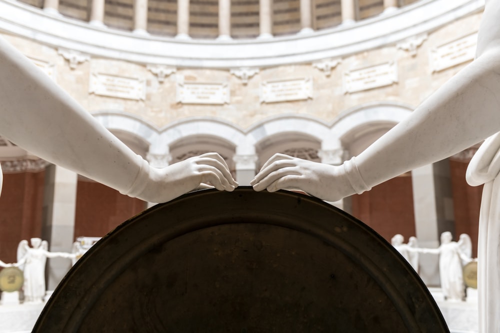 a statue of two hands holding a round object