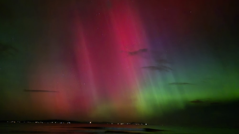 the aurora bore is visible in the sky above the water