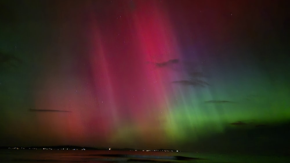 O furo da aurora é visível no céu acima da água