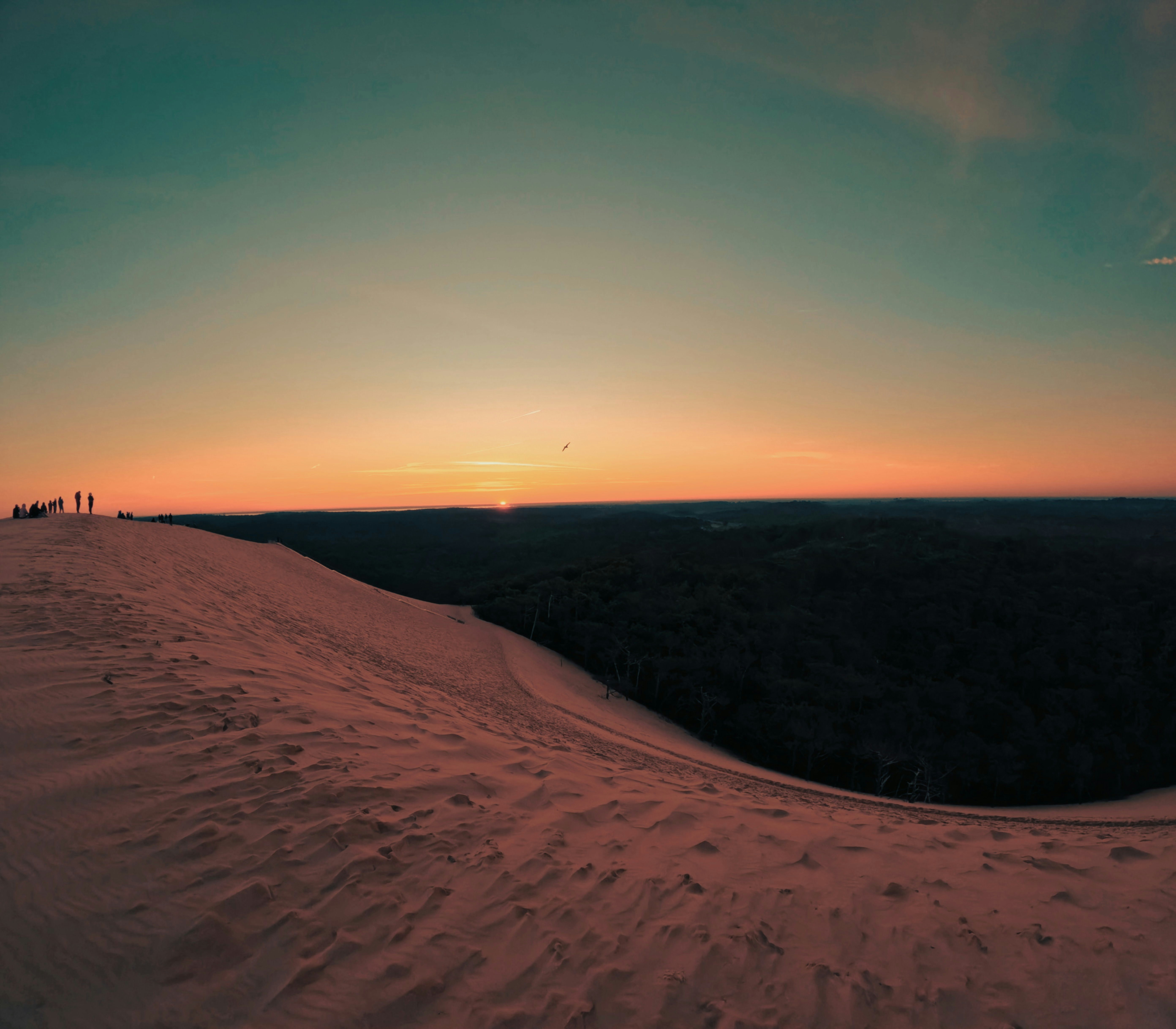 the sun is setting over a snowy hill