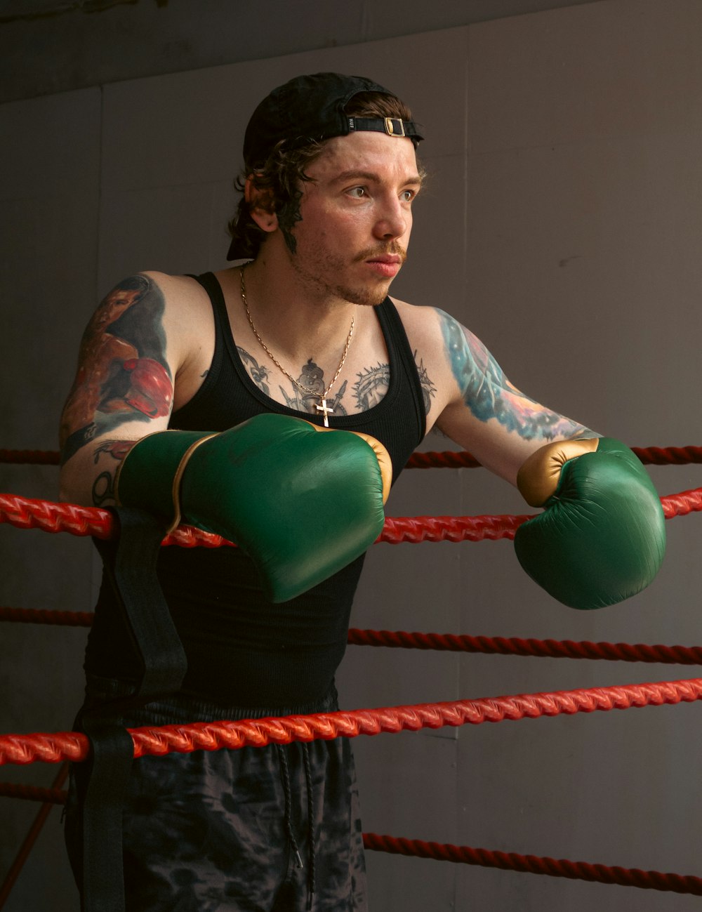 a man with a tattoo on his arm wearing boxing gloves