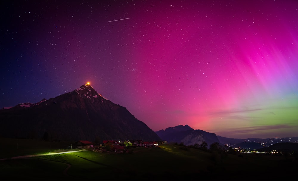 the aurora lights shine brightly in the sky above a mountain