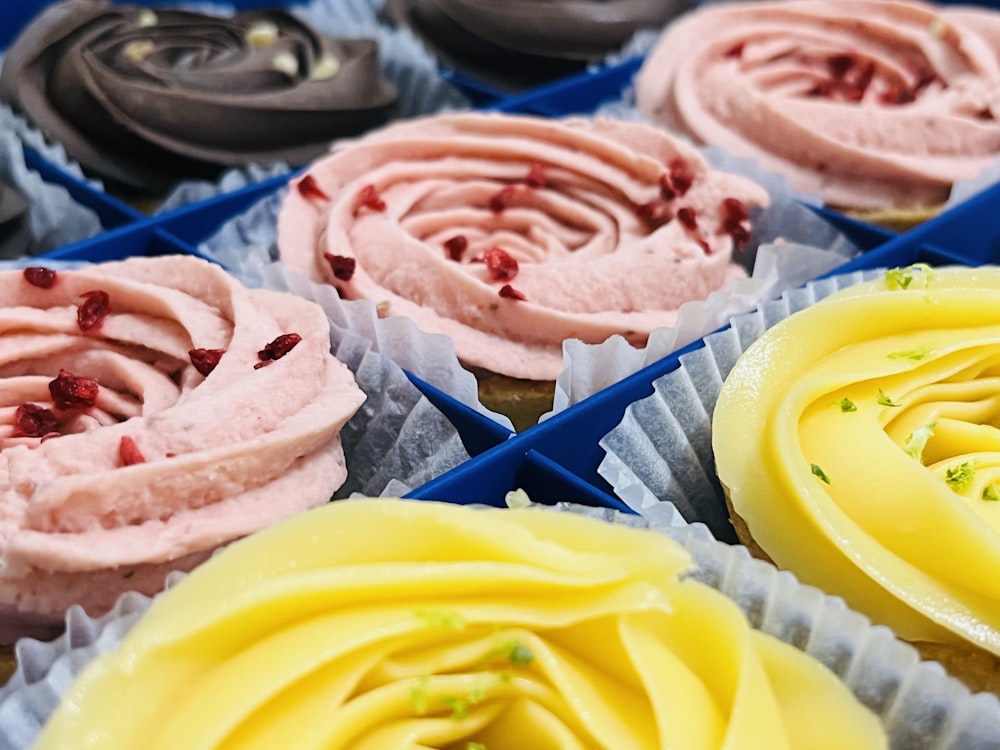 a close up of a tray of cupcakes with frosting