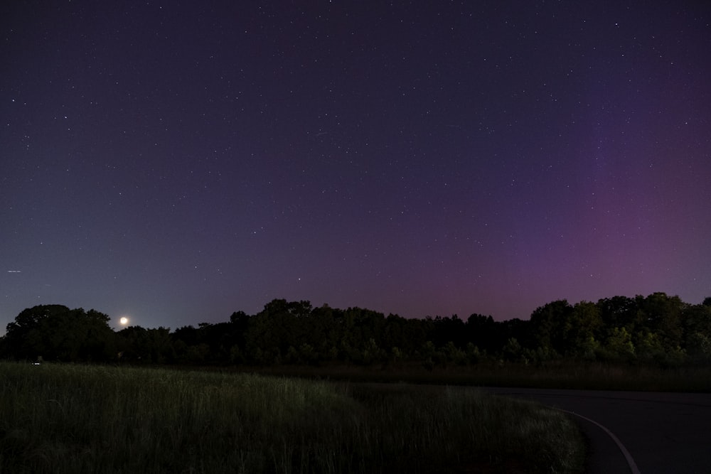 the night sky is lit up with purple lights