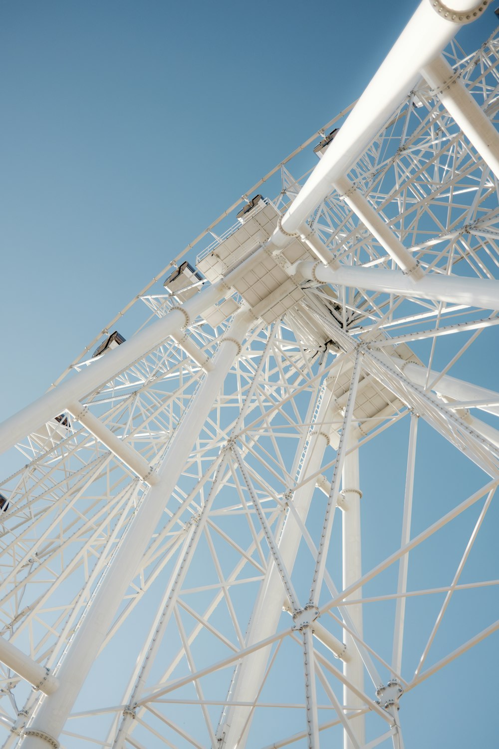 a white ferris wheel against a blue sky