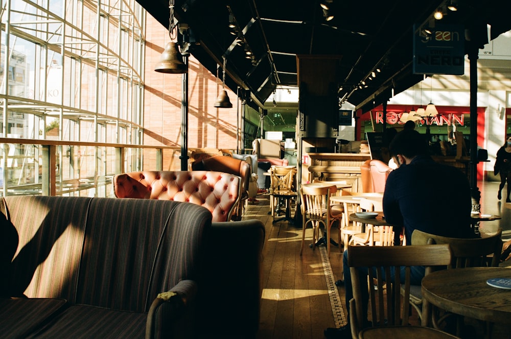 a group of people sitting at tables in a restaurant