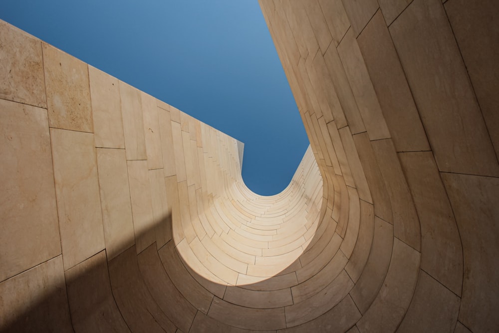 a view of a curved concrete wall with a blue sky in the background