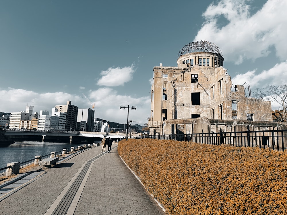 a building with a dome on top of it next to a body of water