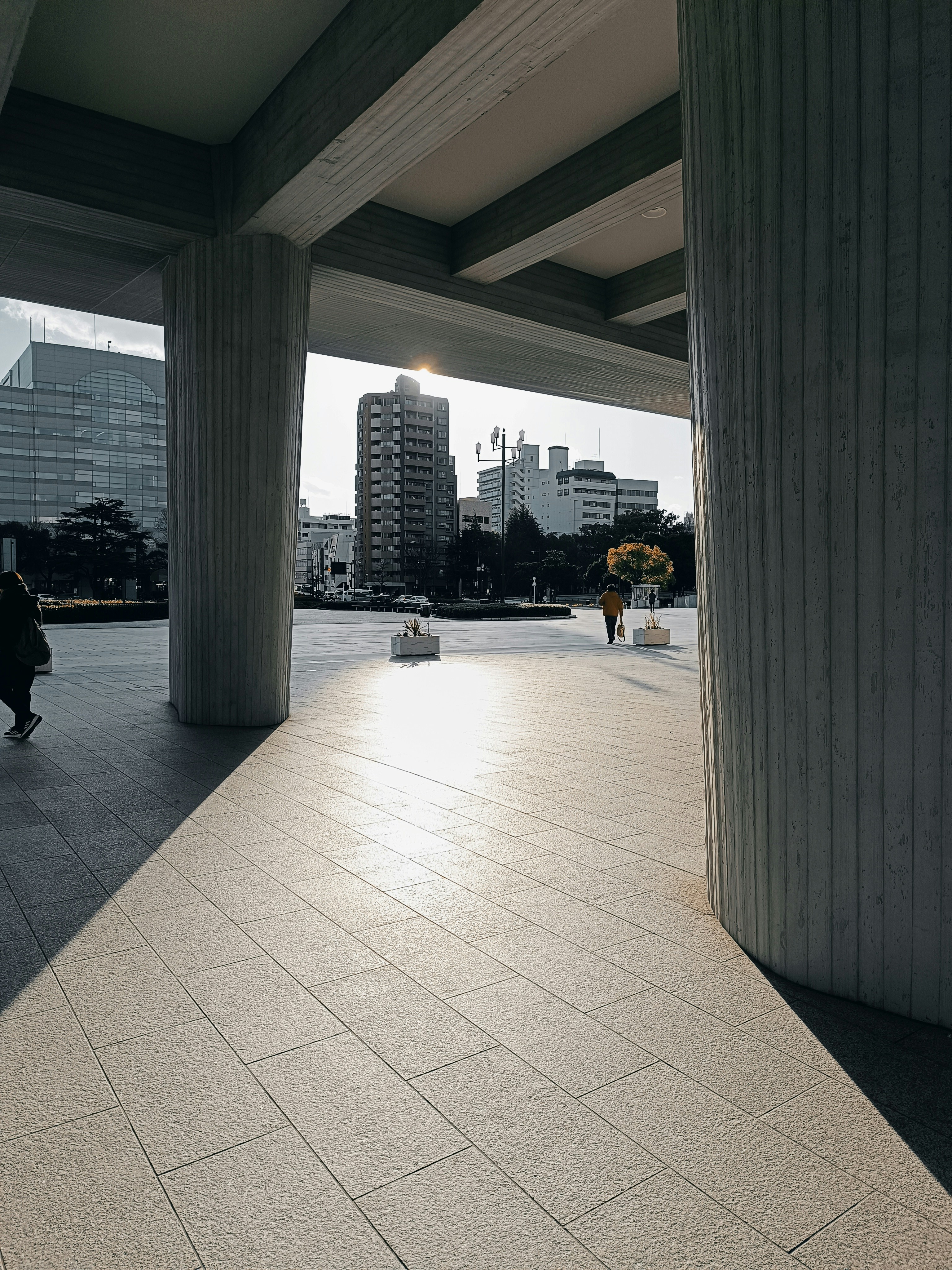 a person sitting on a bench under a bridge