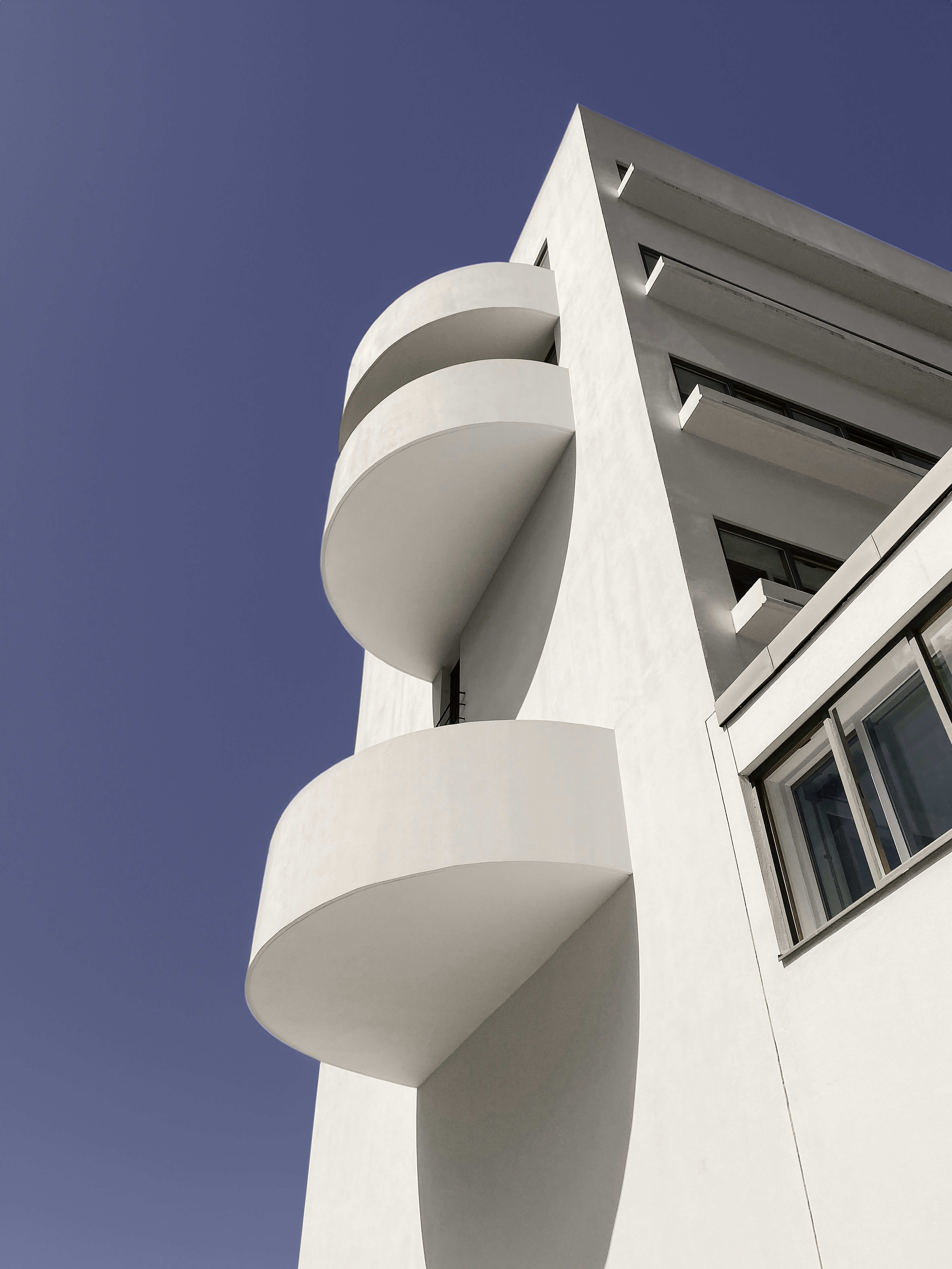 a tall white building with a sky in the background