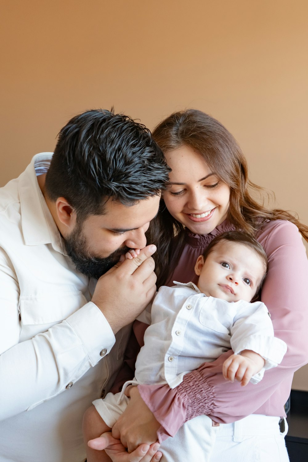 a man and woman holding a baby in their arms