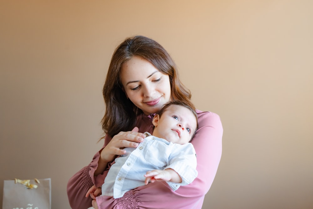 uma mulher segurando um bebê em seus braços