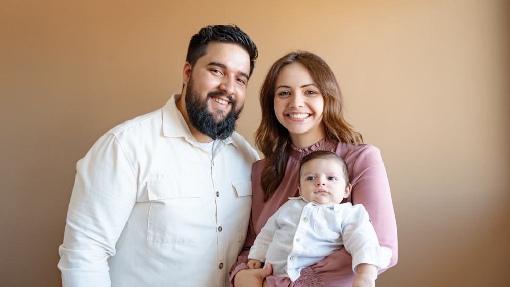 Un homme et une femme posent pour une photo avec un bébé